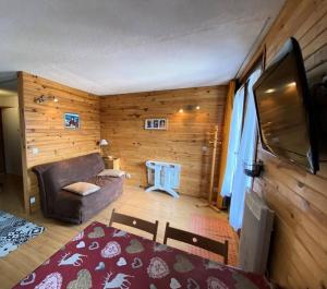 ein Wohnzimmer mit einem Sofa und einem Flachbild-TV in der Unterkunft Résidence Airelles A - 2 Pièces pour 4 Personnes 424 in Risoul