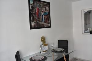 a dining room table with two chairs and a picture on the wall at Mall Apartment 100mp in Bacău