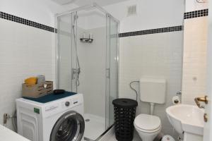 a bathroom with a washing machine and a washer at Mall Apartment 100mp in Bacău