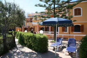 due sedie e un ombrellone di fronte a un palazzo di Mansarda Villa Alf Di Vito a Tropea