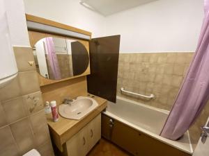 a small bathroom with a sink and a mirror at Plage et commerces à 300 m tout à pied, idéal vacances in Saint-Elme