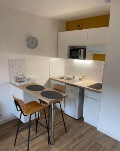 una pequeña cocina con mesa y sillas. en Le Minéral ~ Centre ~ Cosy ~ 2p, en Le Mans