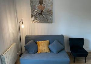 un sofá azul en una sala de estar con una foto de una mujer en Le Minéral ~ Centre ~ Cosy ~ 2p, en Le Mans