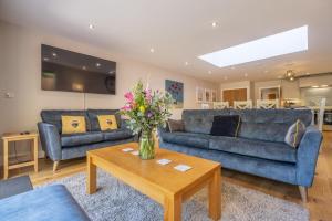 a living room with blue couches and a table at The Goosebec in Burnham Market