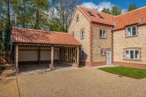 a large brick house with a large garage at The Goosebec in Burnham Market