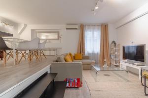 a living room with a couch and a tv at Spacious modern-2Bedroom 2Bathroom-Bernabéu in Madrid