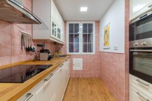 a kitchen with white cabinets and pink tiles at Spacious modern-2Bedroom 2Bathroom-Bernabéu in Madrid