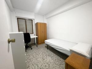 a bedroom with a bed and a desk and a window at Piso completo en Calle Rafael in San Vicente del Raspeig +2 photos