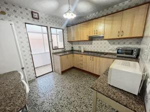 a kitchen with wooden cabinets and a counter top at Piso completo en Calle Rafael in San Vicente del Raspeig