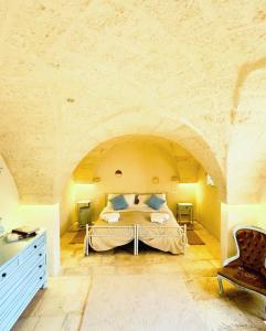 1 dormitorio con 1 cama grande en una pared de piedra en Al Palazzotto, en Fasano