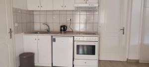 a kitchen with white cabinets and a stove top oven at Lion Apartment in Limenas