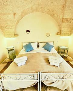 1 dormitorio grande con 1 cama grande con almohadas azules en Al Palazzotto, en Fasano