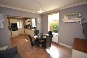 a dining room with a table and chairs and a kitchen at Luxurious Victorian Home by the sea - Myana House in Lowestoft