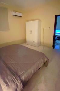 Un dormitorio con una cama y un armario. en شقة بغرفه نوم وصالة, en Az Zulfi