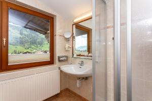 baño con lavabo y ventana en Hotel Bichlingerhof, en Westendorf