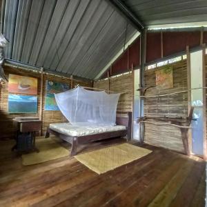 a room with a bed with a mosquito net at Sumatra Ecolodge in Sungaipisang