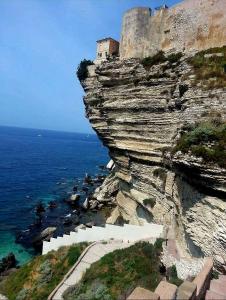 a building on a cliff next to the ocean at Appartement Kallisté, Logements avec vue citadelle de Bonifacio in Bonifacio