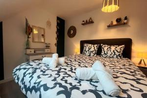 ein Schlafzimmer mit einem großen Bett mit Kissen darauf in der Unterkunft La Prestigieuse - MALO’Cation in Leffrinckoucke