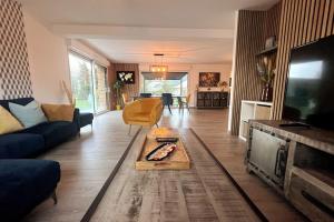 ein Wohnzimmer mit einem Sofa und einem Tisch in der Unterkunft La Prestigieuse - MALO’Cation in Leffrinckoucke