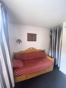 een klein bed in een kamer met rode en witte stippellijnen bij Résidence Betelgeuse - 2 Pièces pour 6 Personnes 984 in Risoul