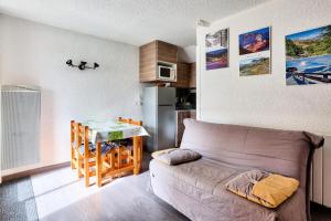 ein Wohnzimmer mit einem Sofa und einer Küche in der Unterkunft Résidence Le Hameau - maeva Home - Studio 4 personnes - Sélection 854 in Vars