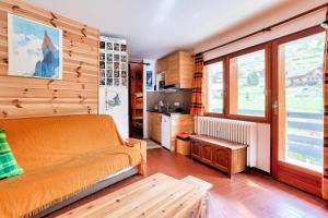 a bedroom with an orange bed and a kitchen at Résidence Vars Sainte Marie - maeva Home - Studio 5 personnes - Confort 864 in Vars