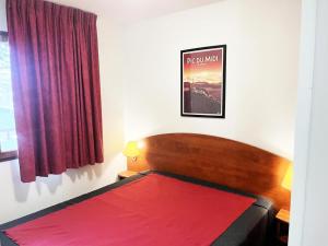 1 dormitorio con 1 cama con manta roja en Résidence Pic Du Midi - 2 Pièces pour 4 Personnes 594, en La Mongie