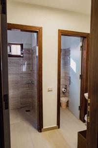a bathroom with a shower and a glass door at The Wind Farm in Dahab