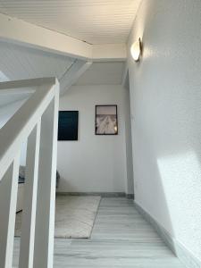 um corredor com uma parede branca e uma imagem na parede em Magnifique appart à 5 min des plages et commerces em Moliets-et-Maa