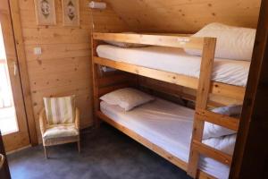 雷阿隆的住宿－Chalet Aiguilles - Chalets pour 8 Personnes 214，一间卧室配有两张双层床和椅子