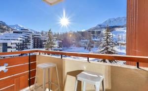 balcón con 2 taburetes y vistas a las montañas cubiertas de nieve en Résidence Le Seignon - maeva Home - Appartement 3 pièces 6 personnes - Pre 054 en Vars