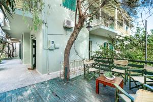 Un patio con bancos y una mesa y un árbol. en Old Boat 12, en Nikiana