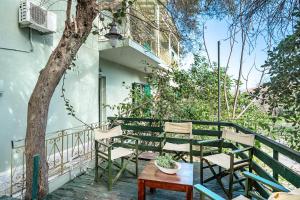 Un balcón con sillas, una mesa y un árbol en Old Boat 12, en Nikiana 4 fotos más