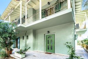 a house with a green door and a balcony at Old Boat 12 in Nikiana