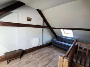 ein Wohnzimmer mit einem blauen Sofa im Dachgeschoss in der Unterkunft Résidence Mais Fortchorges-chorges - Maisons & Villas pour 6 Personnes 424 in Chorges