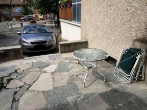 einen Tisch und einen Stuhl sowie ein Auto, das auf einer Straße geparkt ist in der Unterkunft Résidence Mais Fortchorges-chorges - Maisons & Villas pour 6 Personnes 424 in Chorges