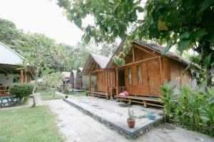 a wooden house in the middle of a yard at The Lavana Cici Bungalow Senggigi in Senggigi