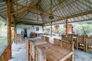 a large pavilion with a wooden table and chairs at The Lavana Cici Bungalow Senggigi in Senggigi