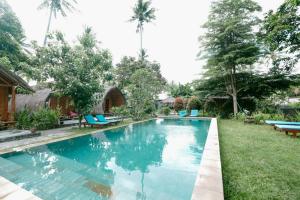 a swimming pool in the yard of a house at The Lavana Cici Bungalow Senggigi in Senggigi