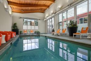 an indoor swimming pool with orange chairs and a poolside at Aloft Minneapolis in Minneapolis