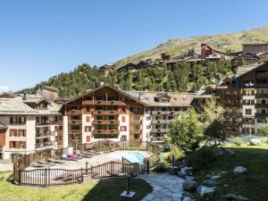 un gran edificio de apartamentos frente a una montaña en Résidence Les Arcs Le Village - maeva Home - Appartement pièces - Sélecti 691 en Arc 1950