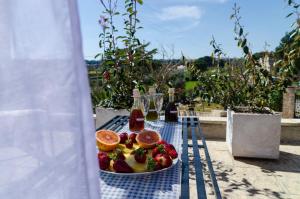 a plate of fruit sitting on a table on a table at Trullo Il Divenire in Martina Franca +34 photos