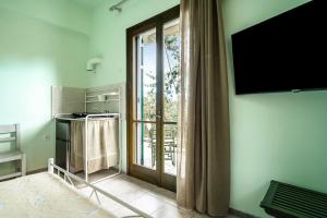 Habitación con ventana grande y TV en la pared. en Old Boat double studio 5, en Nikiana