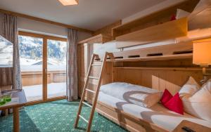 a bedroom with two bunk beds and a desk at Hotel Bichlingerhof in Westendorf