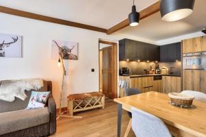 アーク 1950にあるRésidence Les Arcs 1950 Le Village - maeva Home - Appartement charmant vue montagne 3 pièces 8 personnes - Prestige - super Home MAE-9711のダイニングテーブルとキッチンのあるリビングルーム