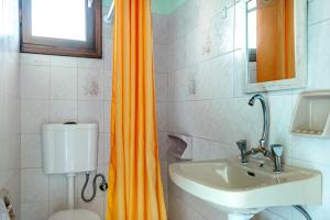 baño con cortina de ducha naranja y lavamanos en Old Boat double studio 10, en Nikiana 12 fotos más