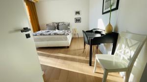 a bedroom with a bed and a desk and a table at House FLOW, 3 room with terrace, free 2 parking in Bratislava