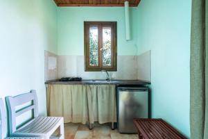 una cocina con fregadero y ventana en Old Boat double studio 10, en Nikiana