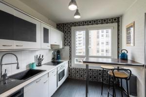 uma cozinha com armários brancos, um lavatório e uma janela em Le VIP - Parking privé citadine em Rouen