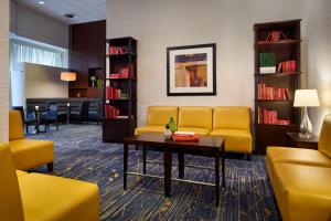 a waiting room with a yellow couch and a table at BWI Airport Marriott in Linthicum Heights